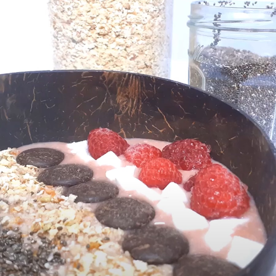 Smoothie bowl à la framboise et coco dans un bol noir