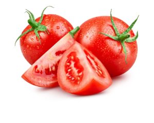 deux tomates entières rouges et deux quarts de tomates sur fond blanc