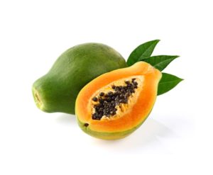 Une papaye entière à côté d'une demi papaye sur fond blanc