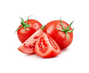 Deux tomates entières à côté de deux quarts de tomates surgelés sur fond blanc